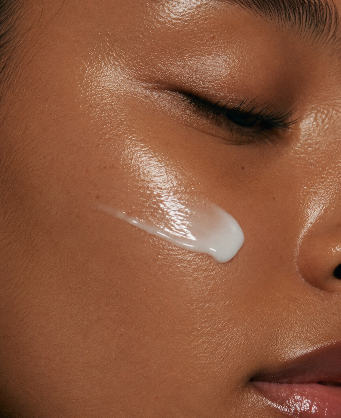 Close-up of a person applying cream to their face