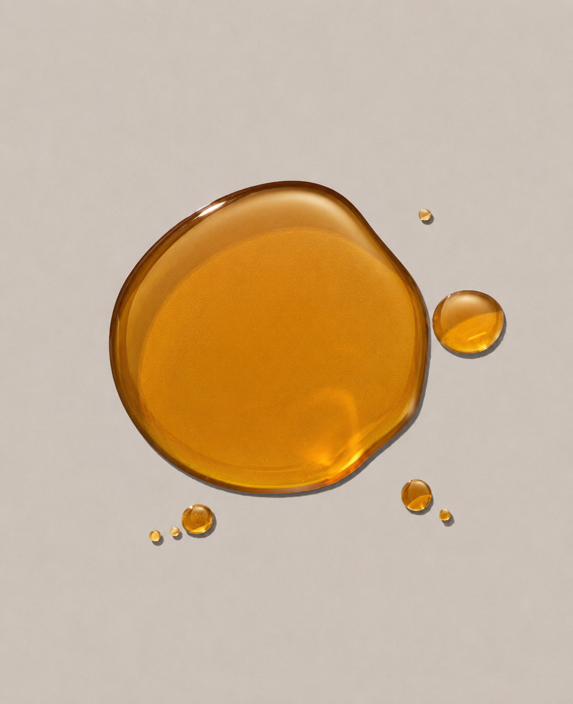 Amber-colored liquid droplets on a beige background